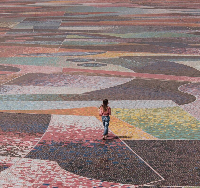 woman in black shirt and black pants walking on red and white concrete floor